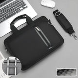 Black laptop bag with handle and shoulder strap on a gray surface with a laptop and mouse.