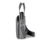 Sideview of grey crossbody bag on a white background