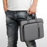 Person holding a gray laptop or macbook bag against a white background